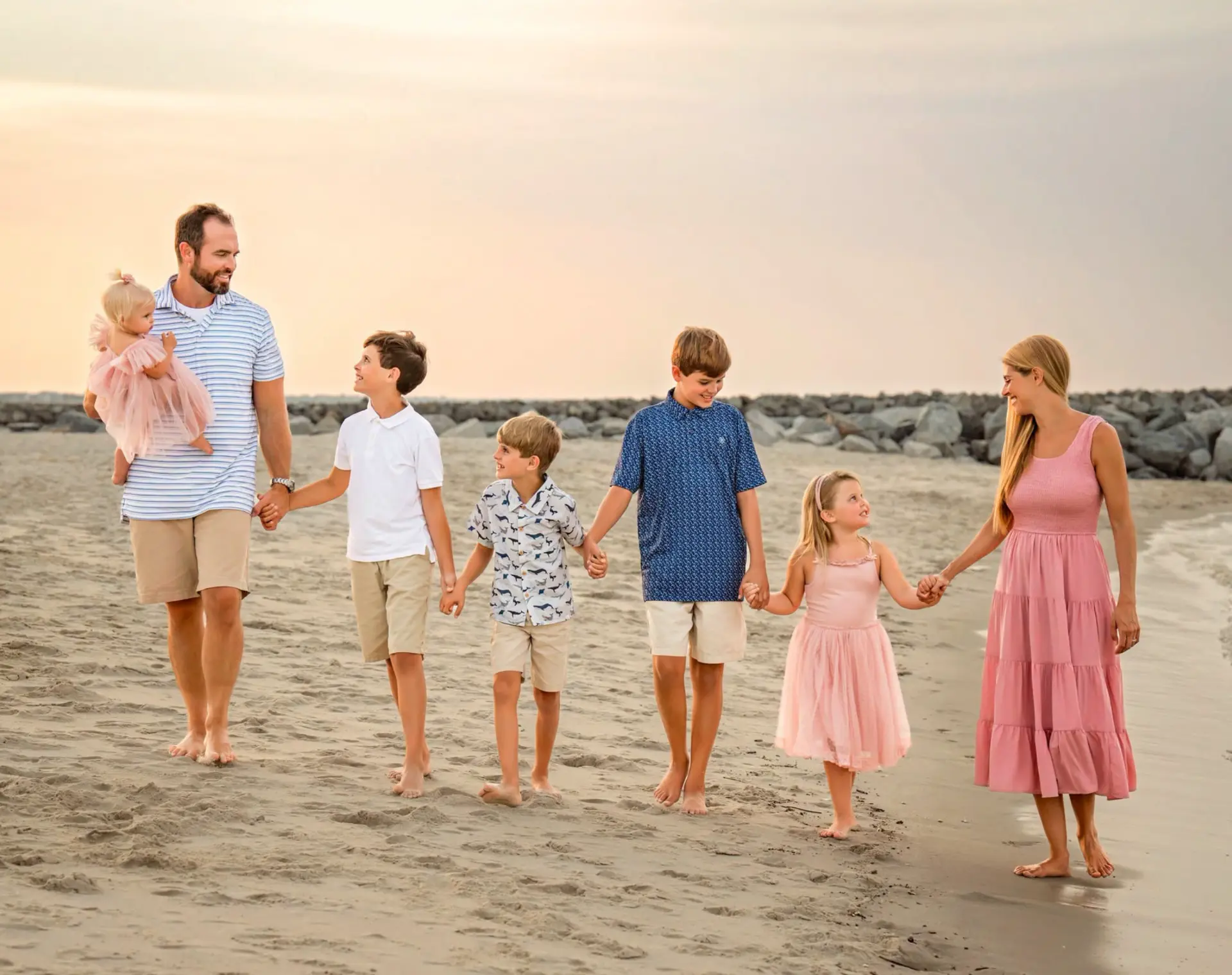 A family walking together on the beach at sunset
